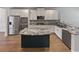 Modern kitchen with stainless steel appliances and granite island at 607 Stream Ct, Fairburn, GA 30213
