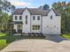 Two-story farmhouse with white siding, gray doors, and a large driveway at 2587 Kingsley Ne Dr, Marietta, GA 30062
