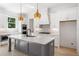 Modern kitchen with white cabinets, gray island, and gold pendant lighting at 2587 Kingsley Ne Dr, Marietta, GA 30062