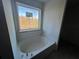 White bathroom vanity and garden tub with window at 690 Calvet Way, Cumming, GA 30041