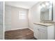 Bathroom with white shaker vanity, marble shower, and luxury vinyl plank flooring at 3686 Thurman Rd, Atlanta, GA 30349