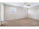 Well-lit bedroom with neutral walls and carpet, featuring two windows and a ceiling fan at 3686 Thurman Rd, Atlanta, GA 30349