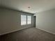 Bright bedroom featuring carpet and two windows at 5547 Bent Grass Way, Douglasville, GA 30135