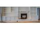 Spacious living room featuring a brick fireplace and built-in shelving at 1060 River Cove Rd, Social Circle, GA 30025