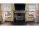 Modern fireplace with dark stone and mantel, flanked by windows at 250 Windsor Way, Fairburn, GA 30213