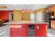 Large kitchen island with granite countertop and red cabinetry at 250 Windsor Way, Fairburn, GA 30213