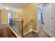 Upstairs hallway with carpeted flooring and a wooden railing at 250 Windsor Way, Fairburn, GA 30213