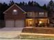 Two-story brick home with a two-car garage and landscaped yard at 7940 White Oak Loop, Lithonia, GA 30038