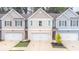 Three-unit townhome building with attached garages and landscaping at 7573 Knoll Hollow Rd, Lithonia, GA 30058