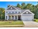 Two-story home with gray siding, stone accents, and a two-car garage at 714 Ocmulgee Xing, Locust Grove, GA 30248