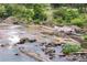 View of a river flowing over rocks in a natural setting at 714 Ocmulgee Xing, Locust Grove, GA 30248