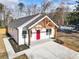 White farmhouse with red door and a large driveway at 860 Gardner Sw St, Austell, GA 30168