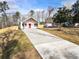 White farmhouse with red door and a long driveway at 860 Gardner Sw St, Austell, GA 30168