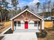 White farmhouse with red door and a large driveway at 860 Gardner Sw St, Austell, GA 30168
