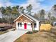 White farmhouse with red door and a large driveway at 860 Gardner Sw St, Austell, GA 30168