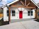 White farmhouse exterior with a red door, wood beams, and a covered porch at 860 Gardner Sw St, Austell, GA 30168