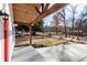 Inviting front porch with wood beams, red door, and view of wooded area at 860 Gardner Sw St, Austell, GA 30168