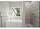 Bathroom with shower, bathtub, and a window overlooking the backyard at 576 Rockwell Sw St, Atlanta, GA 30310