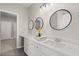 Modern bathroom with double vanity, large mirrors, and white cabinets at 576 Rockwell Sw St, Atlanta, GA 30310