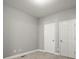 Well-lit bedroom with neutral walls, carpet flooring, and two doors at 576 Rockwell Sw St, Atlanta, GA 30310