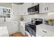 Modern kitchen with white cabinets, stainless steel appliances, and white quartz countertops at 576 Rockwell Sw St, Atlanta, GA 30310
