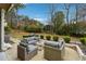 Cozy patio furniture on a spacious concrete patio, overlooking a fenced backyard with mature trees at 3937 Ashford Dunwoody Ne Rd, Brookhaven, GA 30319