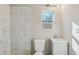 Updated bathroom with a white pedestal sink and marble-tiled shower at 1591 Athens Sw Ave, Atlanta, GA 30310