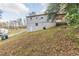 House backyard with sloping terrain and mature trees at 3597 Fairlane Nw Dr, Atlanta, GA 30331