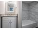 Updated bathroom with granite vanity, white cabinets, and marble-tiled shower/tub combo at 4557 Greenleaf Sw Cir, Atlanta, GA 30331