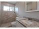 Modern bathroom with marble shower, granite vanity, and window at 4557 Greenleaf Sw Cir, Atlanta, GA 30331