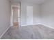 Well-lit bedroom with neutral walls and carpet flooring, plus access to a hallway at 4557 Greenleaf Sw Cir, Atlanta, GA 30331