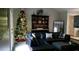 Spacious living room with sectional sofa, Christmas tree, and decorative shelves at 11350 Cranwood Cv, Roswell, GA 30075