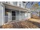 Quaint front porch with white railing and black front door, leaves scattered on the ground at 1102 Forest East Dr, Stone Mountain, GA 30088