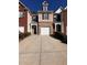 Two-story brick townhome with attached garage and driveway at 2429 Birkhall Way, Lawrenceville, GA 30043