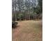 Spacious backyard with mature trees and a fire pit area at 360 Chestnut Dr, Covington, GA 30016