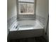Bathroom with corner bathtub and gray mosaic tile at 360 Chestnut Dr, Covington, GA 30016
