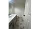 Modern bathroom with gray vanity, white countertop, and wood-look tile floor at 360 Chestnut Dr, Covington, GA 30016