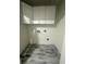 Small laundry room with tile floor and cabinets at 360 Chestnut Dr, Covington, GA 30016