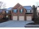 Brick house with three-car garage and a large driveway at 8178 Lochley Dr, Fairburn, GA 30213