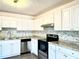 Updated kitchen with white cabinets and granite countertops at 3945 Peninsula Ct, Lawrenceville, GA 30044