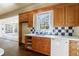 Kitchen with wood cabinets, white appliances, and a view into a sunroom at 1490 Lee Peters Rd, Loganville, GA 30052