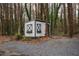 White storage shed with gray trim nestled in a wooded area at 1337 Benteen Park Se Dr, Atlanta, GA 30315