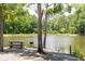 Peaceful lakeside picnic area with wooden table and benches at 726 Ocmulgee Xing, Locust Grove, GA 30248