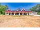 Brick home with covered patio and red trim at 1730 Etchison Spur, Loganville, GA 30052