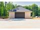 Detached brick garage with a dark roll-up door at 1730 Etchison Spur, Loganville, GA 30052