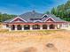 Luxury home with large covered patio, red accents, and brick exterior at 1730 Etchison Spur, Loganville, GA 30052