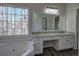 Bathroom with granite vanity, soaking tub and window at 3822 Deercreek Dr, Powder Springs, GA 30127