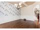 Formal dining room with hardwood floors, chandelier, and decorative wallpaper at 4850 Roosevelt Cir, Cumming, GA 30040