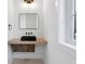 Modern powder room featuring a black vessel sink and wood vanity at 120 Thome Dr, Alpharetta, GA 30022