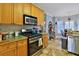 Kitchen with oak cabinets, stainless steel appliances, and tile floor at 625 Piping Rock Pt, Lawrenceville, GA 30043